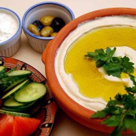baba ghanoush, czyli arabska pasta z pieczonego bakłażana i tahini, podana w glinianej miseczce jako mezze, oblana oliwą z oliwek z pierwszego tłoczenia