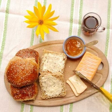 bułeczki z melasą i przyprawą mahlep, posypane białym sezamem podane z masłem, dżemem, serkiem pleśniowym i arabską słodką herbatą