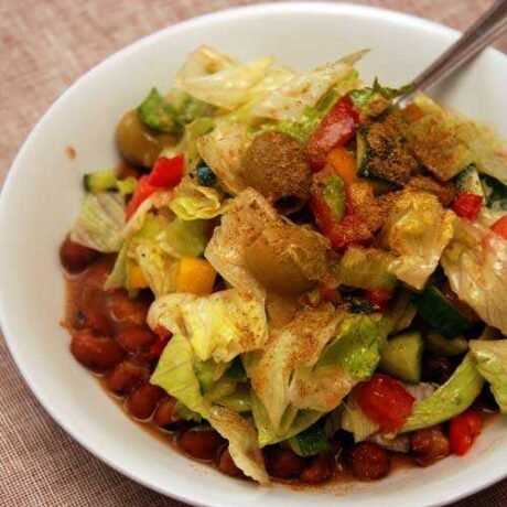 foul mdammas, czyli tradycyjne danie z arabskiego bobiku podane z sałatką ze świeżych warzyw i zielonymi oliwkami, obsypane mieszanką arabskich przypraw