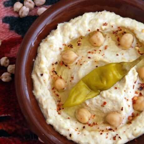 hummus z gotowanej cieciorki polany oliwą z oliwek i oprószony mieloną papryką