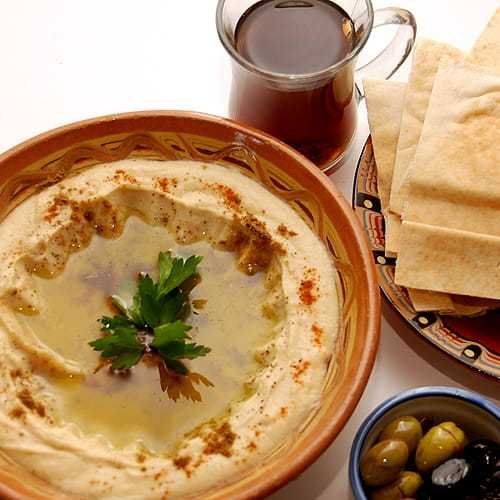 hummus z gotowanej cieciorki polany oliwą z oliwek i oprószony mieloną papryką