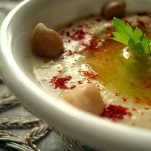 hummus z gotowanej cieciorki polany oliwą z oliwek i oprószony mieloną papryką