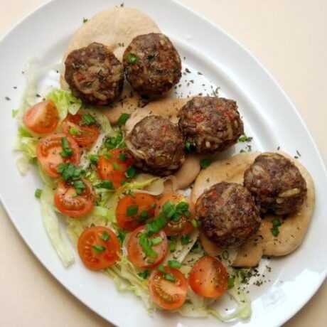 kofta, czyli arabskie klopsiki z mięsa mielonego i ryżu podane na chlebkach pita w towarzystwie świeżej sałatki z pomidorkami i szczypiorkiem