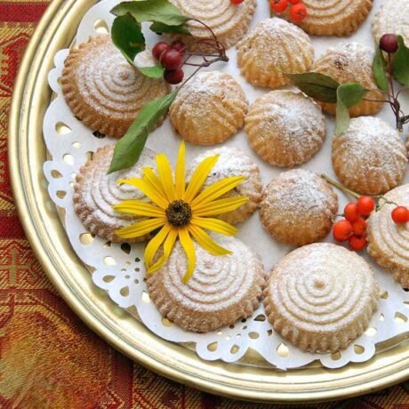 tradycyjne arabskie ciasteczka maamoul z nadzieniem z daktyli i orzechów włoskich, obsypane cukrem pudrem