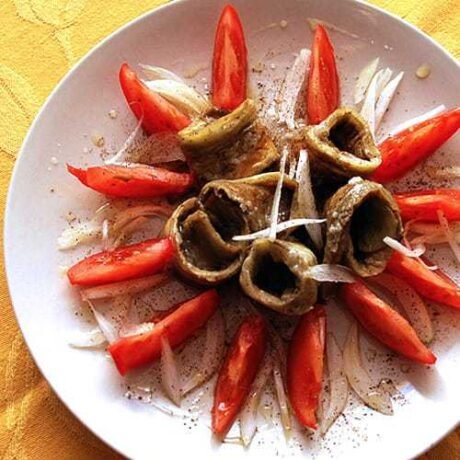 sałatka z pieczonych bakłażanów podana z pomidorkami icebulką pociętą w piórka i polana oliwą z oliwek z pierwszego tłoczenia